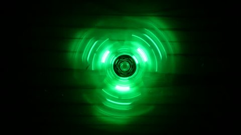 Fidget spinner with led light spinning in the dark with red, blue and green colors