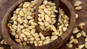 Pine Nuts rotating on a wooden plate as seamless loopable 4K UHD footage