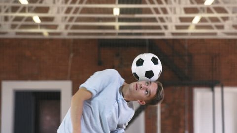 Football freestyle. Young man practices with soccer ball