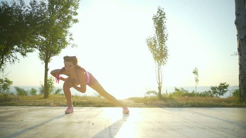 Beautiful young woman doing a warm-up in the morning slow motion