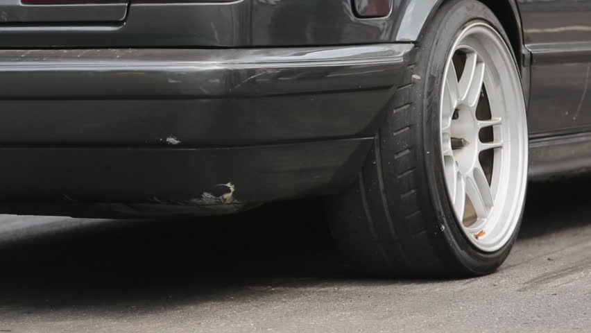 Drag racing car burns rubber off its tires in preparation for the race.