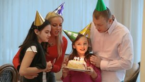 Happy family blowing candles at birthday party