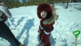 Little girl in winter wear running away from camera and playing with her family