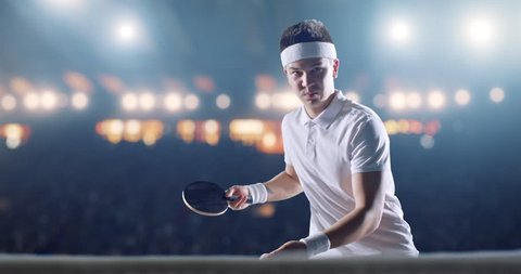 Ping pong player in action on a professional sports arena. He is wearing unbranded clothes. 