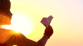 Happy Child playing with paper airplane over sunset background. Slow motion video footage 240 fps. 4K UHD video. High speed camera