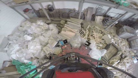 Point of view of a grapple bucket grabbing trash