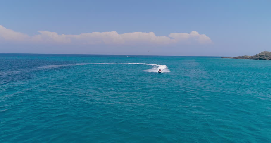 Aerial View Over Man Speeding On Jet Ski Tourist Attraction Exotic Tropical Island Shore Beach At Exotic Greek Island Extreme Sports Vacation Trip Tourism Sport Attraction Paradise Adventure Concept Royalty-Free Stock Footage #30134836