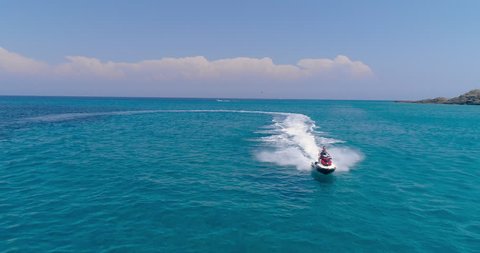 Aerial View Over Man Speeding On Jet Ski Tourist Attraction Exotic Tropical Island Shore Beach At Exotic Greek Island Extreme Sports Vacation Trip Tourism Sport Attraction Paradise Adventure Concept