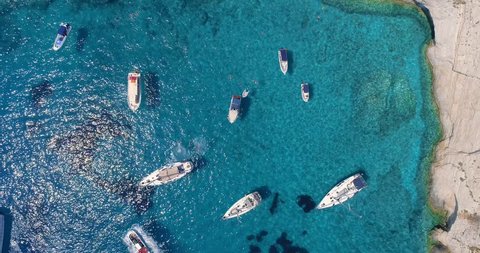 Aerial Drone Shot Passing Over Tourist Boats and Yachts at Rocky Tropical Ocean Island Shore Famous Zante Island Tourist Attraction Summer Travel Concept On Hot Summer Day