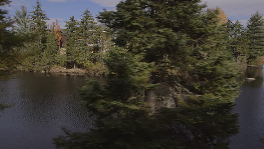 Moving pan shot of sunrise over a lake in the Adirondack Mountains.