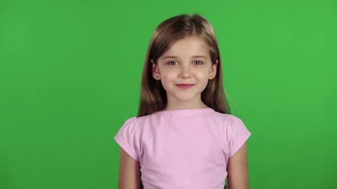 Child genuinely smile at the camera. Green screen. Slow motion