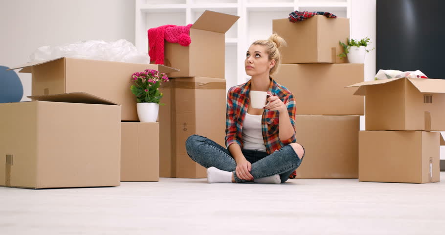 Young woman decorating her new house relaxing on the floor with a mug of coffee