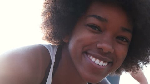 African American woman smiling to the camera. Sporty woman stretching and smiling to te camera.