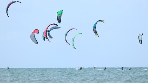 Unidentified peoples kite surfing in the ocean. Multicolour kites surf and blue sky.