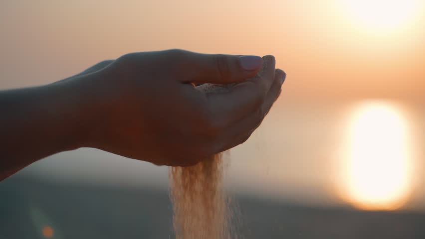Close up of woman pouring sand running through fingers slow motion at the beach with sun flare and blue sky. Beautiful scene of young lady playing with sand on sunrise or sunset. | Shutterstock HD Video #30171955