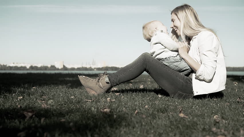 Baby funning with mother on the grass in park