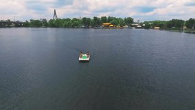 Flying over girls floating pedal boat on lake water HD aerial panoramic video. Women relaxation on river at summer vacation. Recreation leisure nature background