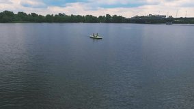 Flying over girls floating pedal boat on lake water HD aerial panoramic video. Women relaxation on river at summer vacation. Recreation leisure nature background