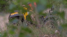 Man driving quad bike HD slow-motion video. All-terrain vehicle riding ATV in forest. Four-wheeler quadricycle transport and extreme sport.