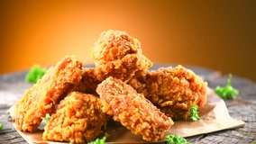 Crispy fried chicken wings and legs on a wooden table rotation 360 degrees. Breaded Crispy fried kentucky chicken tasty dinner. 4K UHD video footage. Ultra high definition 3840X2160 