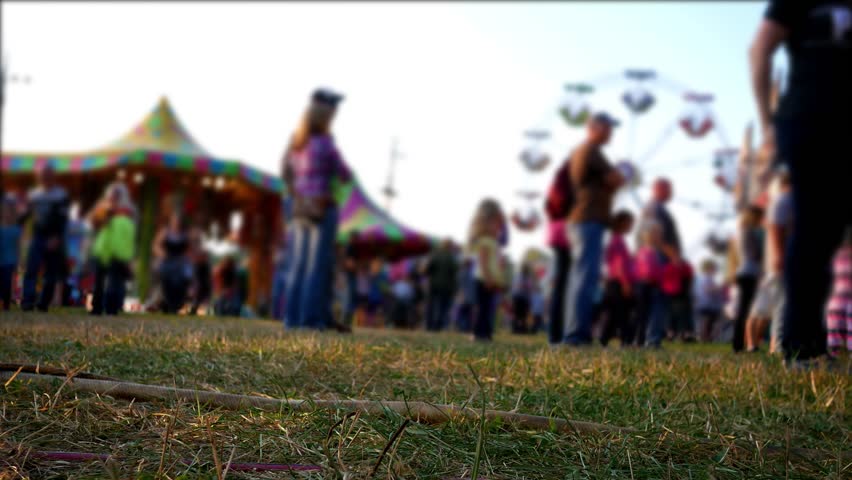 Defocused crowds at an amusement park or county fair in summer