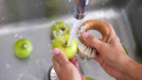 Young Vegan Girl Washing Green Apples with Bamboo Brush. Hand Holding Fresh Fruits Under Running Water in Kitchen Sink. Healthy Lifestyle Hygiene Concept. HD Slowmotion.
