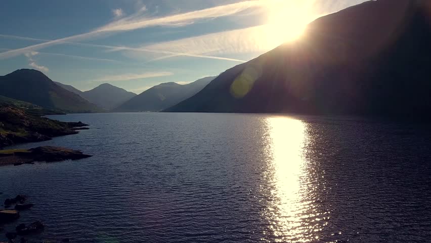 Gorgeous sunrise aerial shot of sunlight reflecting off the surface of a lake in the English Lake District.