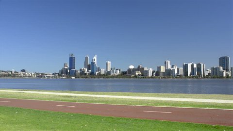 Cyclists riding along a bike path along the edge of the Swan River, with Perth City and the river in the background. (Western Australia)