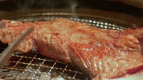 Japanese-style Korean barbecue - Turning grilled beef steak
