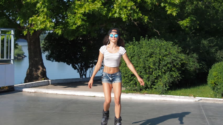 Beautiful girl rolls on roller skates. 