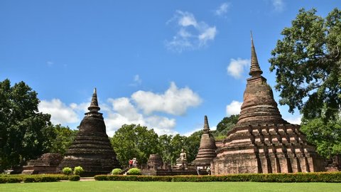 Ancient Pagoda in Sukhothai historical park with travelers, famous tourist attraction in northern Thailand.Time lapse.