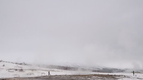 Eruption of Strokkur Geyser in Iceland in winter on a cloudy day

