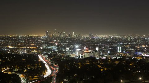 LOS ANGELES, CA, USA - APR 15, 2015: 4K Time lapse zoom in of Downtown Los Angeles from Hollywood Hills with Interstate 101 in the foreground during the evening rush hour
