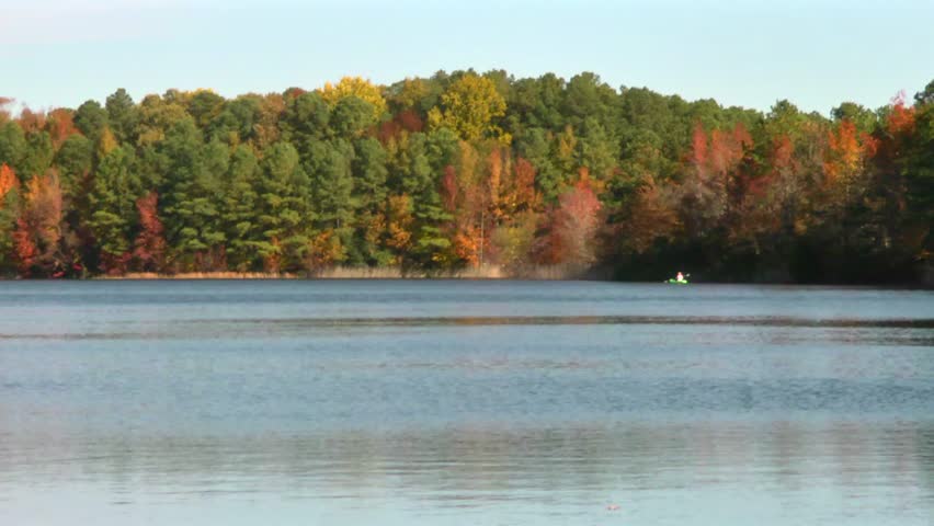 Kayaker enjoys a lake surrounded by beautiful fall color