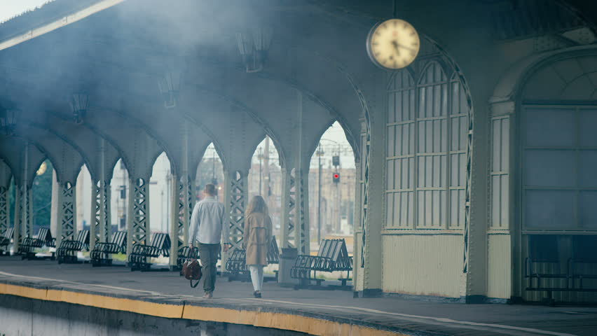 Happy young couple on railway station platform. Shot in Red Epic Dragon