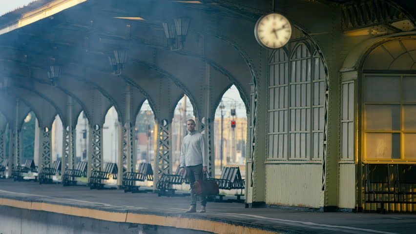 Young handsome standing along at train platform. Shot in Red Epic Dragon