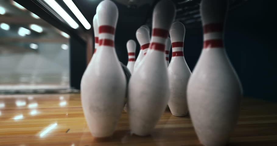 Bowling strike, bowling ball knocks down bowling pins in slow motion