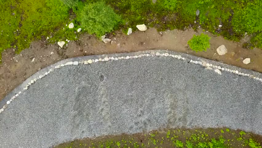 Aerial flight over scenic grassy area with paths