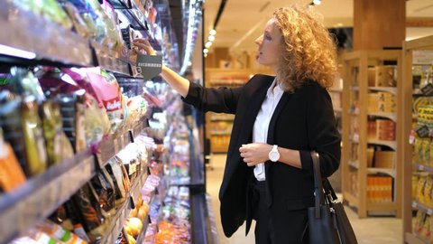 Young Woman Choosing Products In Supermarket. 4K. 