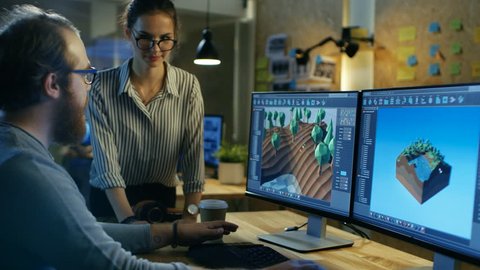 Male Game Developer Talks with Artistic Female Level Designer. Two Displays Show Totally Original Game. They Work in a Creative Office Loft. Shot on RED EPIC-W 8K Helium Cinema Camera.