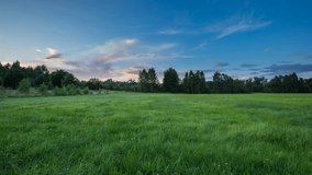 4k time lapse landscape with sunset sky over green meadow. 3840x2160