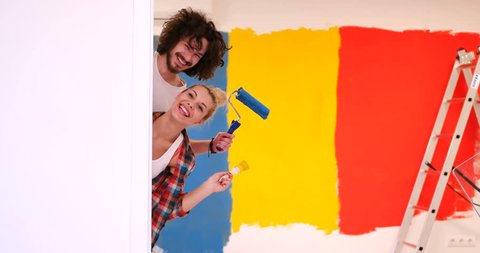 Funny couple just moved into their new appartment and painted wall in crazy colors . Peek a boo behind the wall.