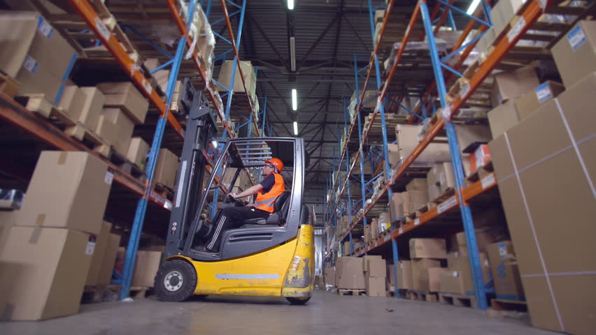 forklift operator puts boxes with goods on the metal racks Royalty-Free Stock Footage #30247303