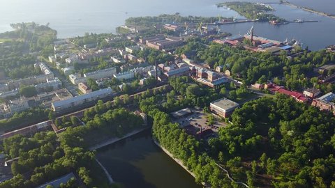 4K aerial video footage view of Kronstadt town center, park, war vessels and boats and view of navy military base near St. Petersburg 700 km from Moscow, Russia on clear summer morning