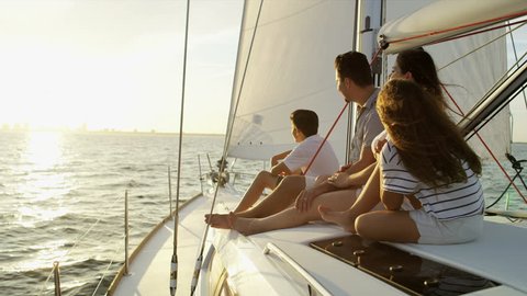 Happy Hispanic family in casual clothing at leisure sailing the ocean on luxury yacht relaxing at sunset RED WEAPON