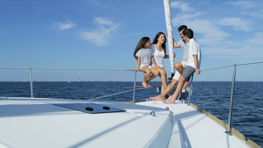 Latin American parents with son and daughter enjoying healthy outdoor living traveling the ocean on luxury yacht RED WEAPON
