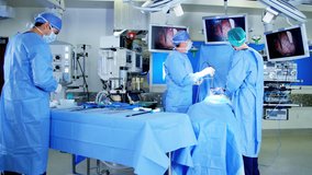 Caucasian European male team in scrubs in the operating theater of European origin using an Endoscopy to specialise in Laparoscopy surgery via camera technology RED DRAGON