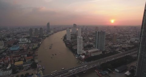 Sathorn And Chao Phraya River At Sunset, Bangkok, Thailand, Aerial Pan Shot
