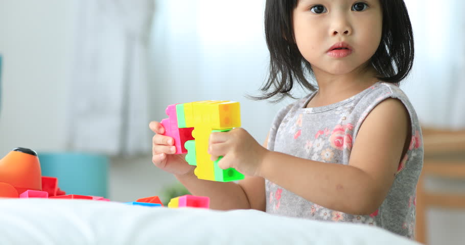 Little asian children playing with colorful construction plastic blocks on white Bed at home . Royalty-Free Stock Footage #30256435