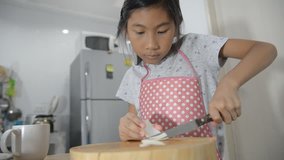 Asian girl chops Onion in kitchen